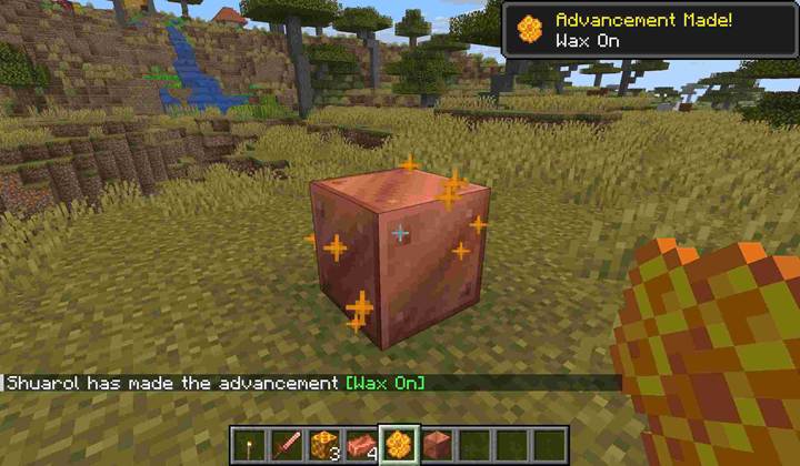 A player in Minecraft applies honeycomb to exposed copper blocks.