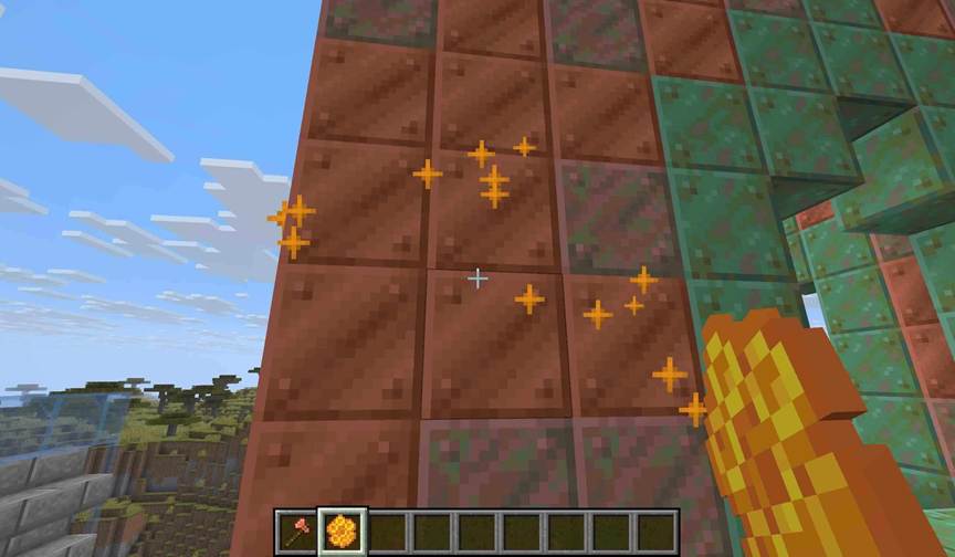 In Minecraft, a player uses honeycomb to preserve a copper roof, freezing its bright orange tone while nearby unwaxed blocks continue to age.